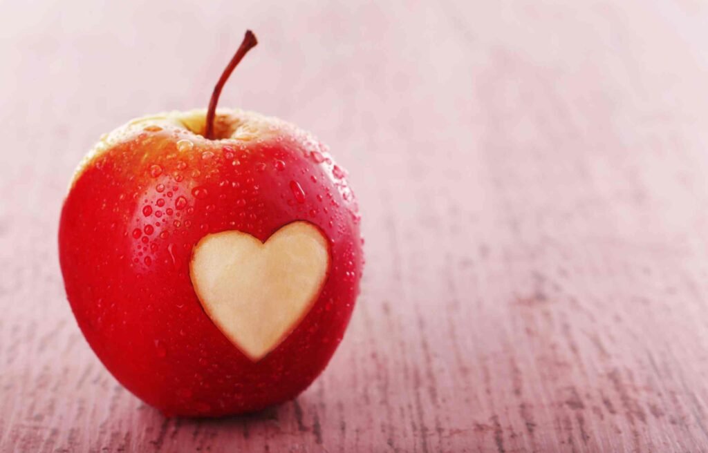 A red heart-shaped symbol glowing softly, representing one of the most enduring romantic symbols of love.