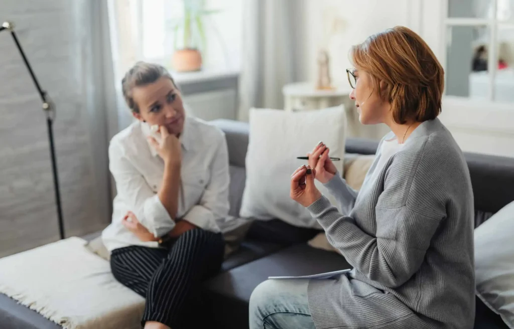 A woman discussing her anxious attachment style during a therapy session to better understand her need for reassurance.