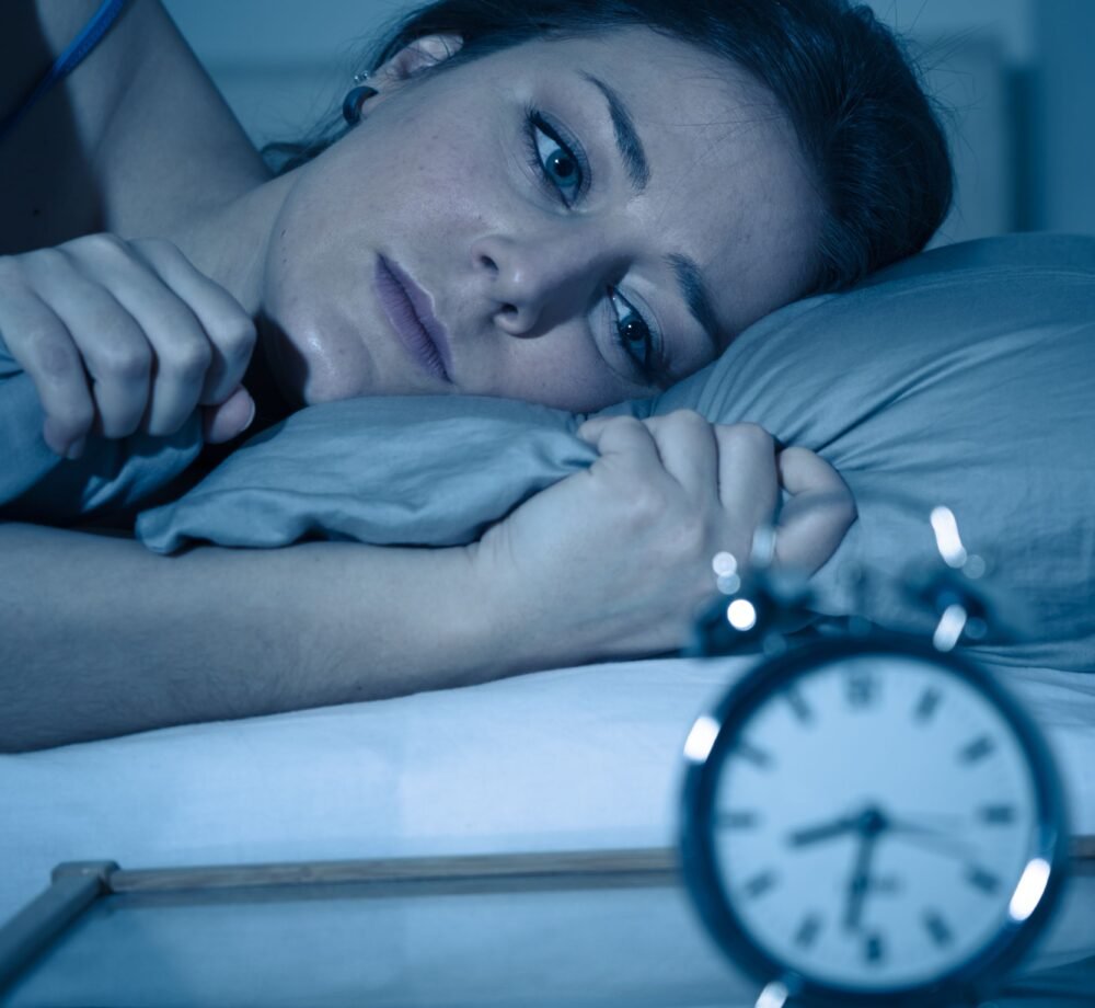 women thinking What Time Should I Go to Bed and she is trying to sleep