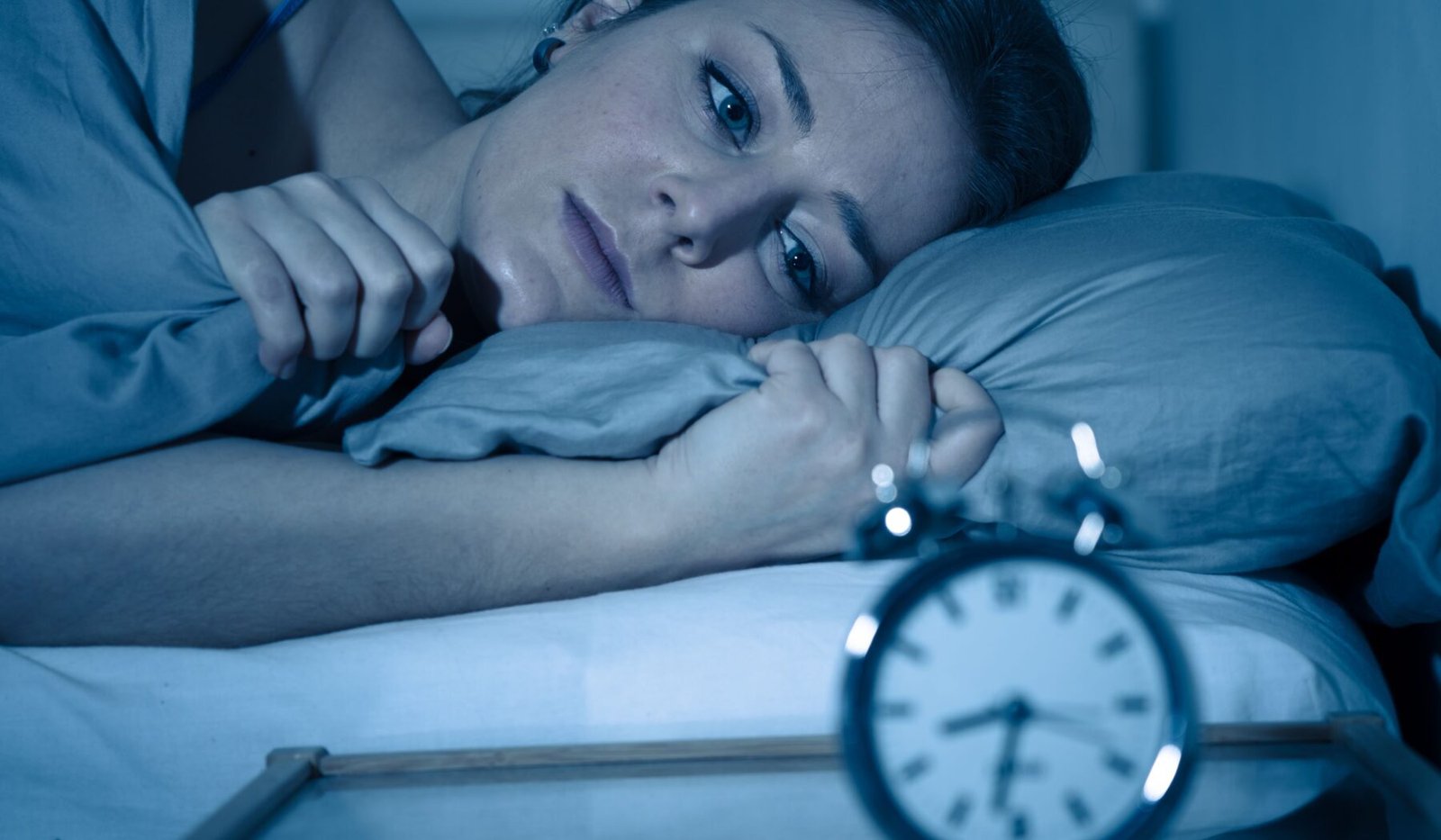 women thinking What Time Should I Go to Bed and she is trying to sleep